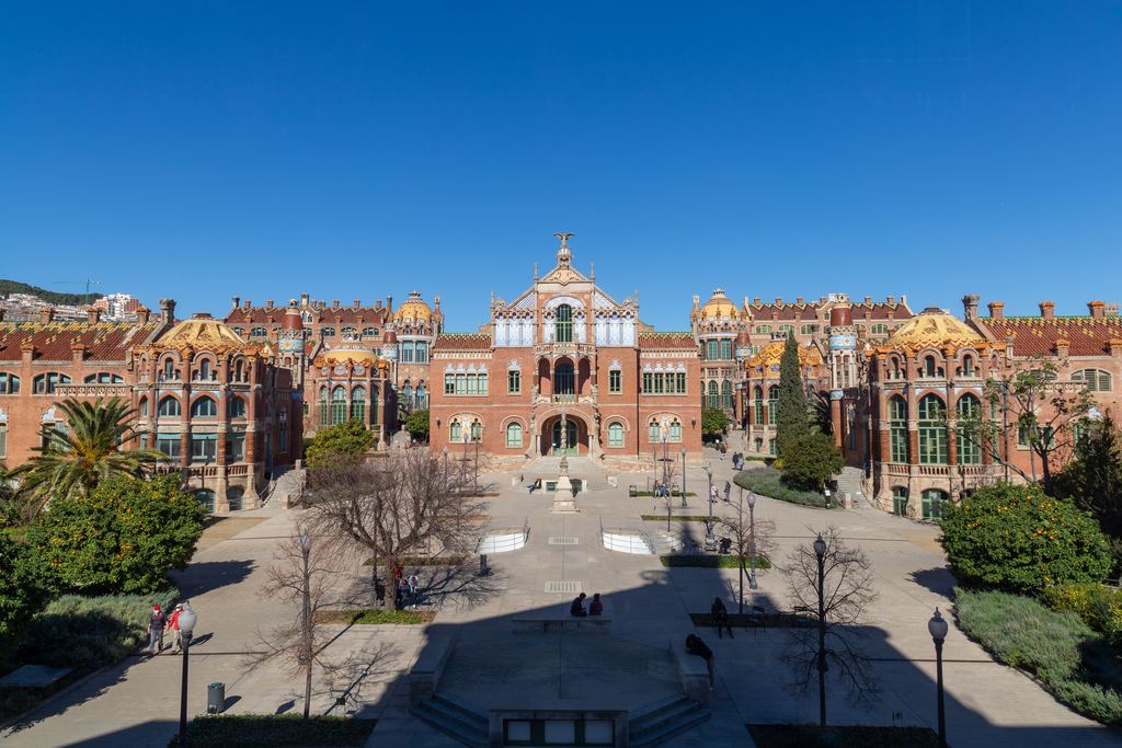 View of the Modernist complex of Sant Pau from the entrance, with the Administration building in the background and the side pavilions nestled among the gardens