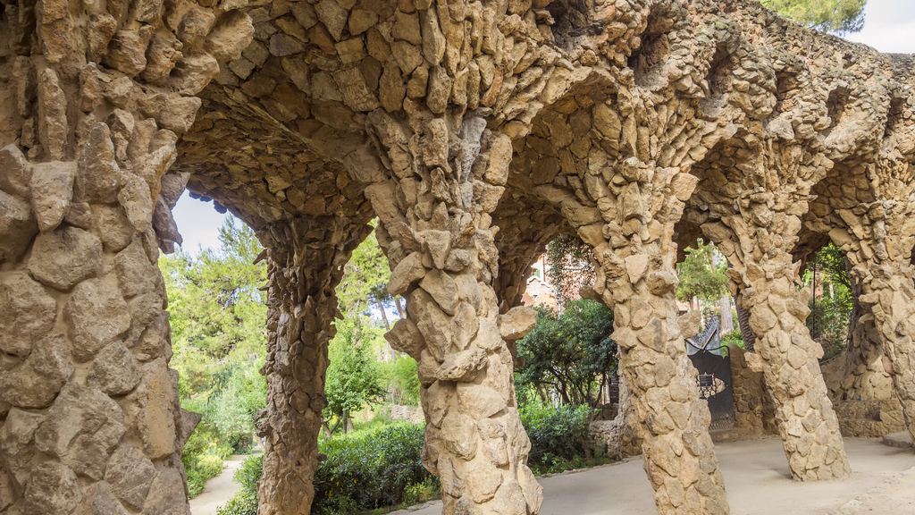 Arcaded viaduct in Park Güell with leaning columns of rough-hewn stone